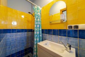 a bathroom with blue and yellow tiled walls and a sink at Apartament Na Skraju Miasta in Mikołajki