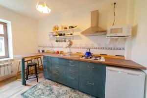 cocina con armarios azules y encimera en Apartament Na Skraju Miasta, en Mikołajki