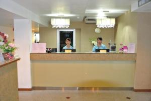 two people sitting at a reception counter in a hotel room at The Blooms Residence in Bangkok