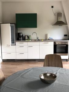 uma cozinha com armários brancos e uma tigela sobre uma mesa em Wohnung im Zentrum des Ruhrgebietes 1A 3.OG em Castrop-Rauxel