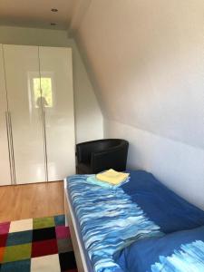 ein Schlafzimmer mit einem Bett mit einem Stuhl und einem Schrank in der Unterkunft Wohnung im Zentrum des Ruhrgebietes 1A 3.OG in Castrop-Rauxel