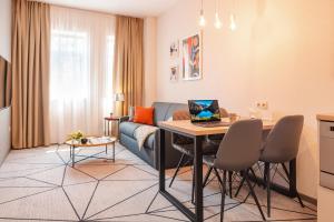 salon z kanapą i stołem z laptopem w obiekcie City Park Apart Hotel by CHM w Kijowie