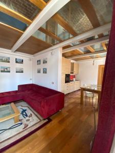 ein Wohnzimmer mit einem roten Sofa und einem Tisch in der Unterkunft Casa Di Vetro in Canino