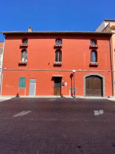 ein großes rotes Backsteingebäude auf einer Straße in der Unterkunft Casa Di Vetro in Canino