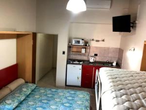 Kleines Zimmer mit einem Bett und einer Küche in der Unterkunft departamento acosta 2 in Paraná