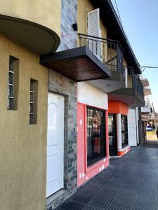 a building with a red door on a street at departamento acosta 2 in Paraná