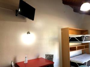 Zimmer mit einem roten Tisch und einem TV an der Wand in der Unterkunft departamento acosta 2 in Paraná