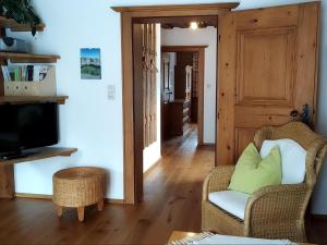 a living room with a chair and a television at Gästehaus Maier in Kitzbühel