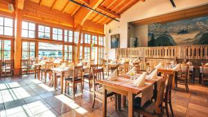 um restaurante com mesas e cadeiras de madeira numa sala em Das Bergmayr - Chiemgauer Alpenhotel em Inzell