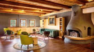 een grote kamer met stoelen en een open haard bij Das Bergmayr - Chiemgauer Alpenhotel in Inzell