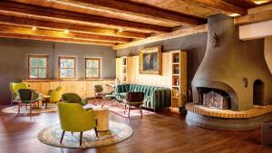 インツェルにあるDas Bergmayr - Chiemgauer Alpenhotelの椅子と暖炉付きの広い部屋