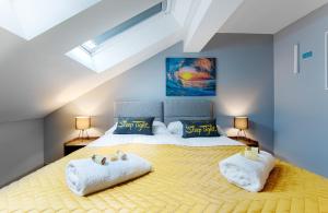 a bedroom with a large bed with towels on it at The Eistedfod Penthouse - Berwyn House in Wrexham