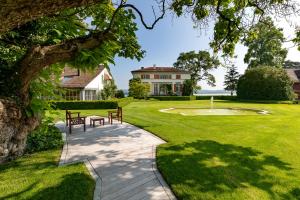 un giardino con due panchine e una casa di LILIENBERG a Ermatingen