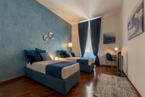 una camera d'albergo con due letti e una sedia di Castel Sant'Angelo Design Apartment a Roma
