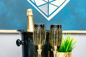 2 verres à champagne assis à côté d'une bouteille de champagne dans l'établissement The Eistedfod Penthouse - Berwyn House, à Wrexham