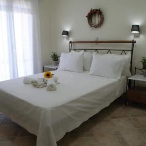 una gran cama blanca con una flor encima en Villa bel fiore, Brand new Great View, en Katouna