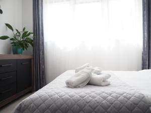 un animal de peluche yace en una cama en Adobe Apartment, en Wroclaw