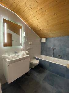 een badkamer met een wastafel, een bad en een toilet bij Pension Haus in der Sonne in Fieberbrunn