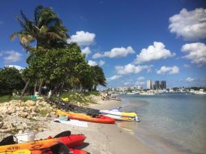 a beach with kayaks on the sand and a city at Casa del Sol 2bd 1ba Cottage Private Pool in West Palm Beach