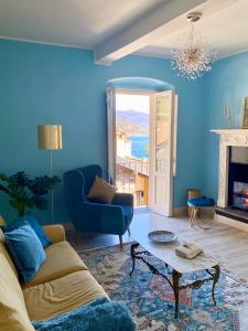 ein blaues Wohnzimmer mit einem Sofa und einem Tisch in der Unterkunft Apartment Italian Charm in Ghiffa