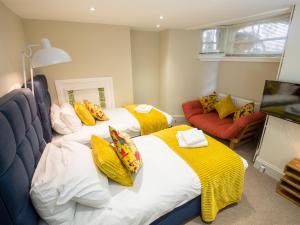 um quarto com duas camas e um sofá em Regency House em Cambridge