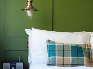 Regency House في كامبريدج: غرفة نوم خضراء بسرير ومخدة ومصباح