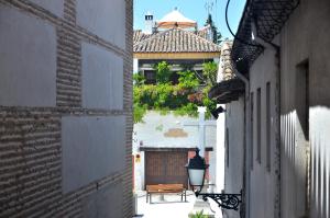 un vicolo con una panchina di fronte a un edificio di Casa Siesta a Granada
