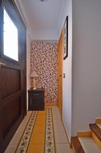 a hallway with a door and a table with a lamp at Casa Siesta in Granada