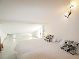 a bedroom with a white bed with two pillows on it at Casa Siesta in Granada