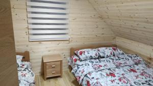 a bedroom with two beds in a wooden room at Zlatni pogled in Zaovine