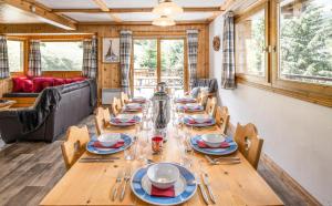 a dining room with a long wooden table and chairs at Chalet Himalaya , 10 Person Chalet with 5 ensuite bedrooms and outdoor jacuzzi in Meribel Centre in Méribel
