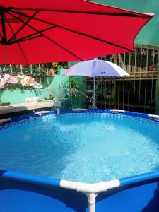 una sombrilla roja y una piscina con una sombrilla roja y blanca en Style House in Cancun en Cancún