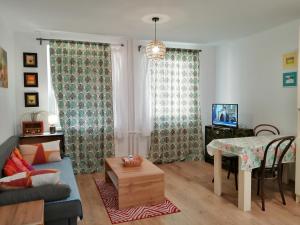 a living room with a blue couch and a table at Slávik Apartment in Dunajská Streda