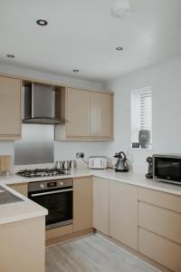 a kitchen with white cabinets and a stove top oven at 2 The Mews, Upper Bath Street in Cheltenham