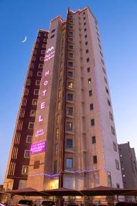 um edifício alto com uma placa na lateral em Magic Suite Plus For Hotel Apartment em Kuwait