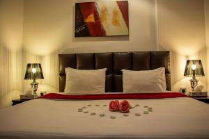 a bedroom with a bed with two roses on it at ماجيك سويت بلس Magic Suite Plus in Kuwait