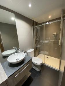 een badkamer met een wastafel, een toilet en een douche bij Suite Anna in Zaragoza