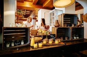 Zwei Frauen stehen in einer Küche und bereiten Essen zu. in der Unterkunft Alpenrose Bayrischzell Hotel in Bayrischzell