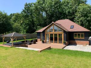 a house with a wooden deck and a gazebo at Chestnut-Lodge is rural, secluded, private with Hot Tub in Maidstone