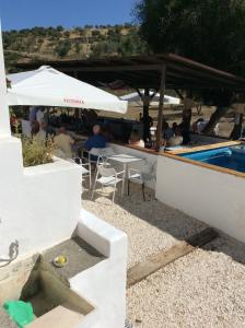 un grupo de personas sentadas en un restaurante junto a una piscina en Amandolas, en Casarabonela