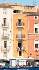 ein hohes Gebäude mit Balkon an der Seite in der Unterkunft Le Petit Bijou Sète, quatre appartements au centre ville, trois avec vue canal in Sète