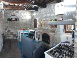 a living room with a stone fireplace and a stove at CASETTA delle ROSE in Assisi