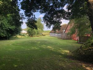 un gran patio verde con un granero y árboles en Solbjerg Skov B&B, en Solbjerg