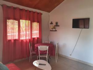 comedor con cortinas rojas y mesa en Cabañas Mountain View, en Volcán