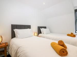 twee bedden met handdoeken in een slaapkamer bij The Keepers Cottage at The Institute Executive Apartments in Keith