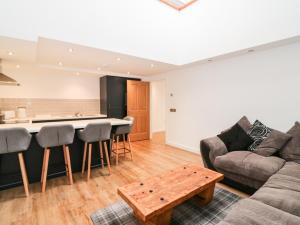 a living room with a couch and a table at The Marriage Room at The Institute Executive Apartments in Keith