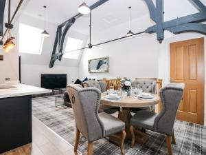 a dining room and living room with a table and chairs at The Clock Tower at The Institute Executive Apartments in Keith