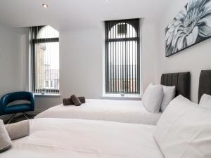 A bed or beds in a room at The Clock Tower at The Institute Executive Apartments