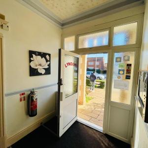 a door to a room with a flower on the wall at Lyndene Holiday Apartments in Skegness