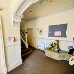 a hallway with an archway and stairs in a house at Lyndene Holiday Apartments in Skegness
